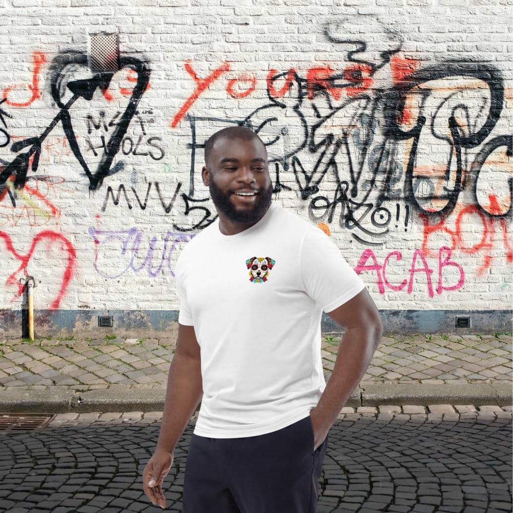 Homme portant un t-shirt Exception blanc de la marque Felpatee avec le design Chien Calavera devant un mur taggué