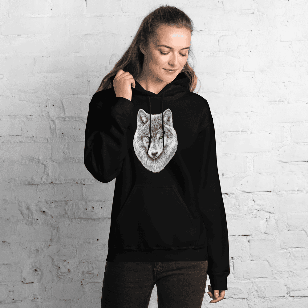 Vue de face d'une femme portant le Hoodie Essentiel noir Instinct Émeraude devant un mur blanc épuré. Un incontournable au quotidien au confort premium avec un design by Mister Felpatee, emblématique de la marque Felpatee.