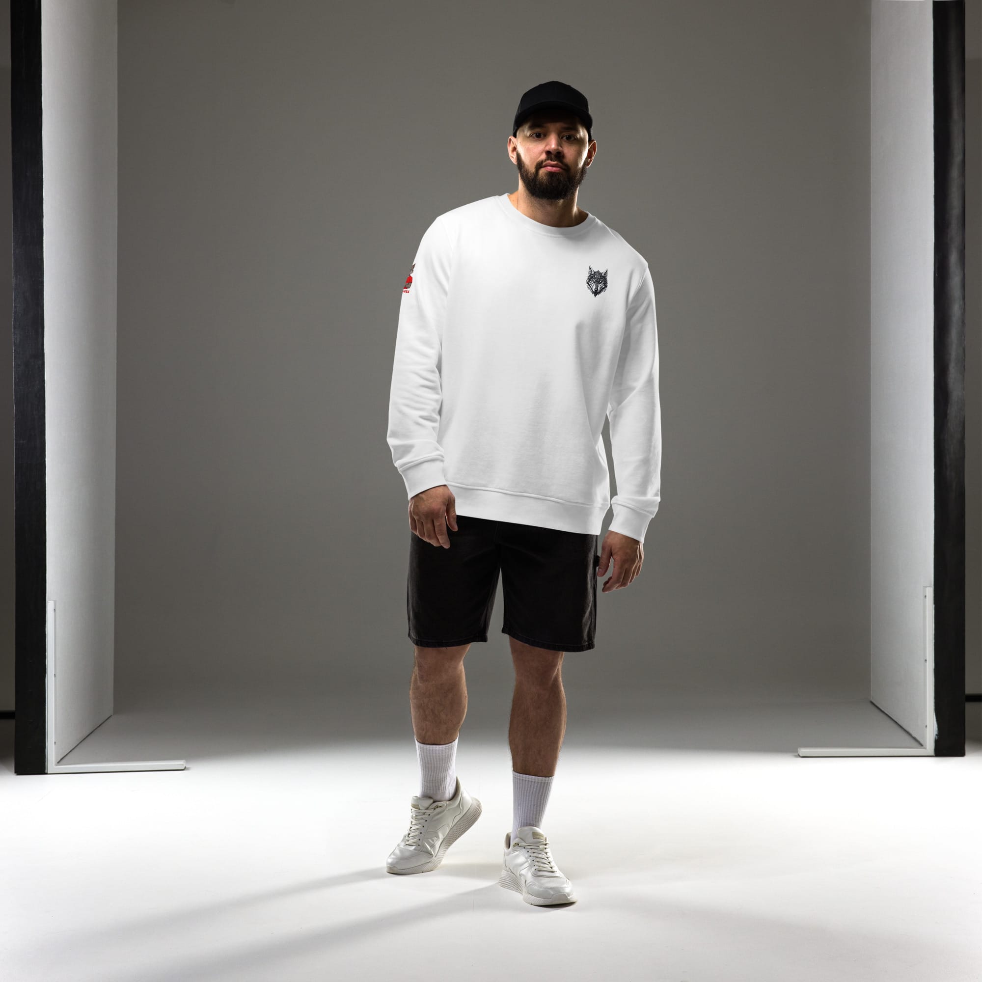 Homme en tenue streetwear complète portant le sweat col rond Alpha blanc. Vue de face montrant le design minimaliste Loup Gardien Runique côté cœur. Look exclusif Mister Felpatee.