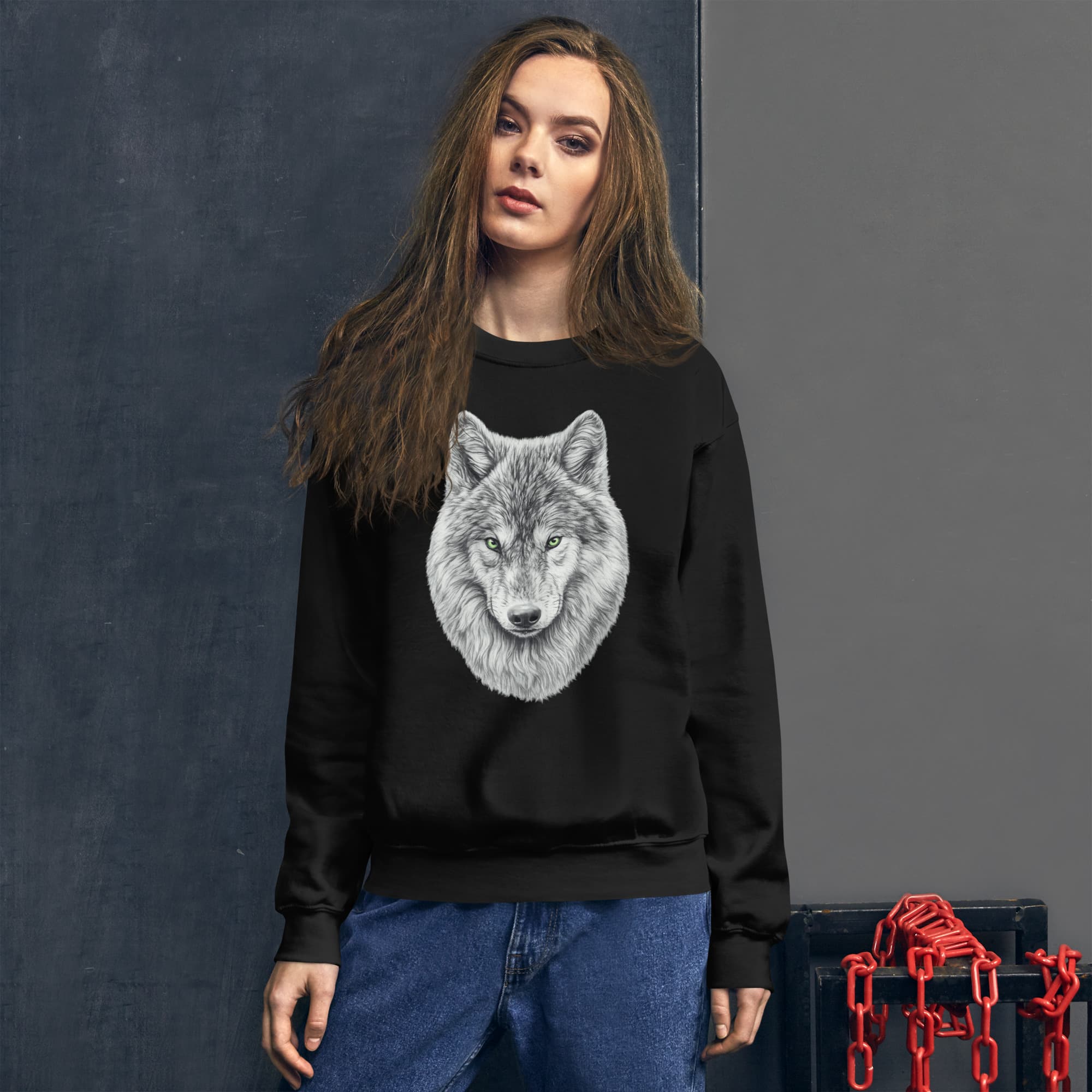 Vue de face d'une femme portant le Sweatshirt Premium noir Instinct Émeraude dans un décor industriel avec des chaînes. Design by Mister Felpatee sur la poitrine offrant un confort premium et une allure urbaine signée Felpatee.
