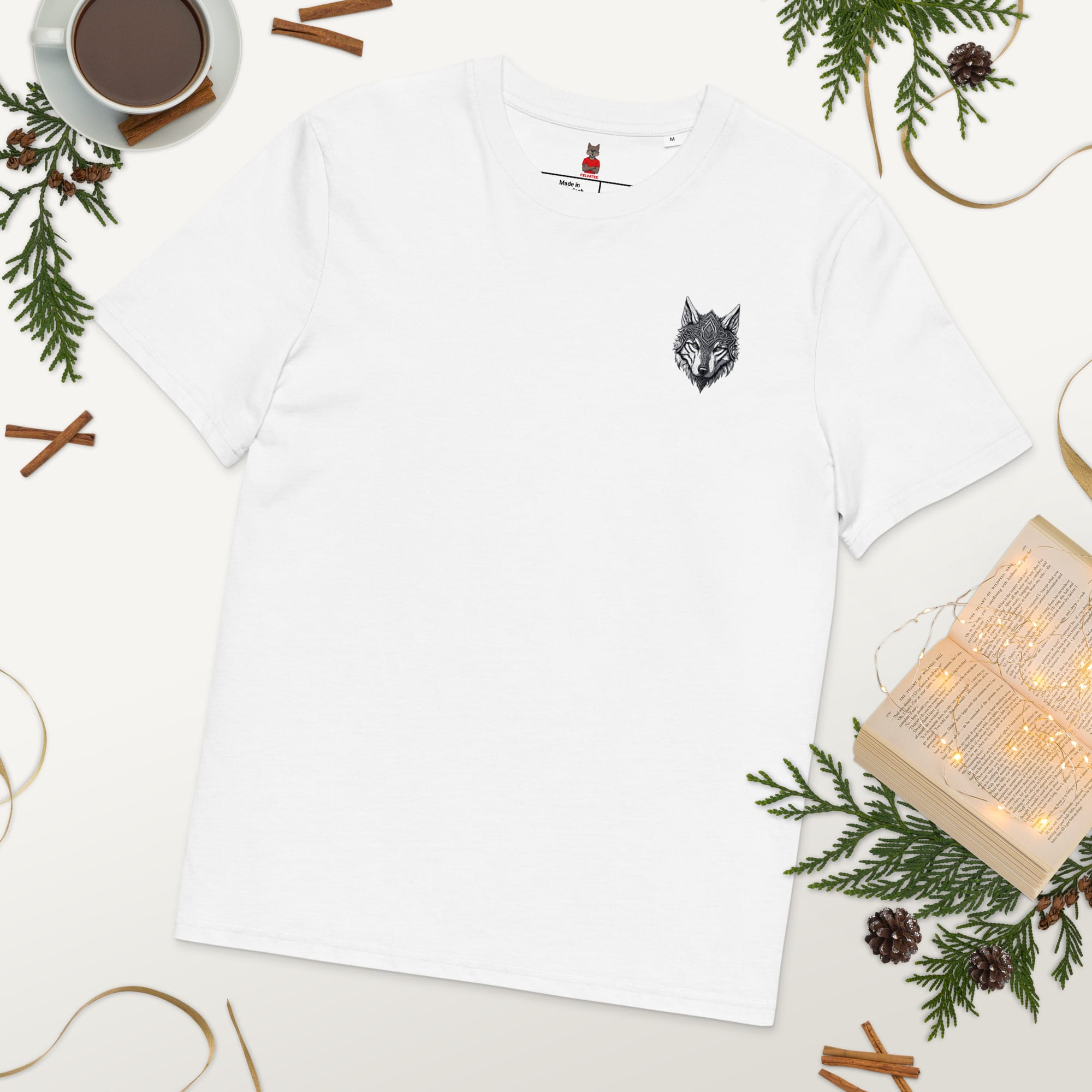 Flat lay (vue à plat) du T-shirt Exception blanc au design minimaliste Loup Gardien Runique, entouré d'éléments naturels et de saison.