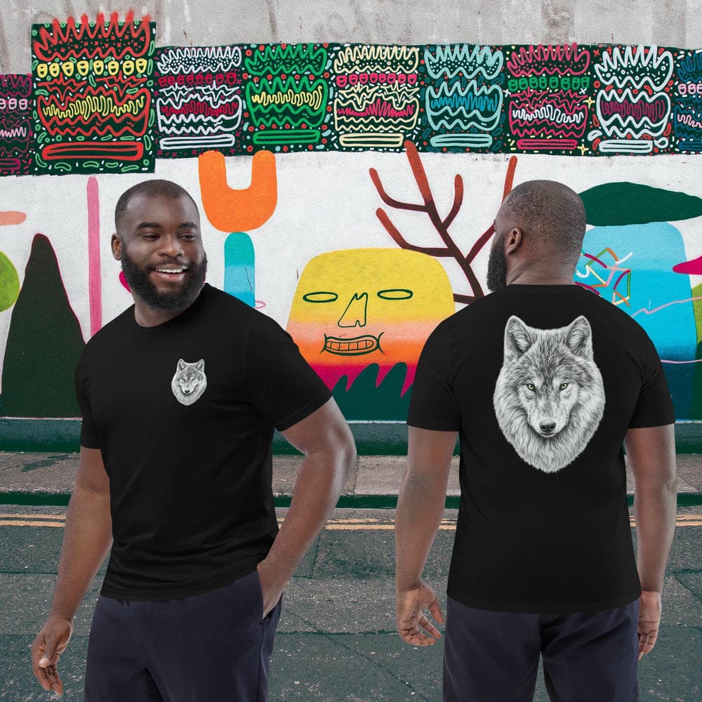 Vue de face et de dos d'un couple en T-shirt Exception noir Instinct Émeraude devant un décor urbain coloré. Une pièce signature au ton mature affichant le Sceau de la Meute et un design artistique complexe.